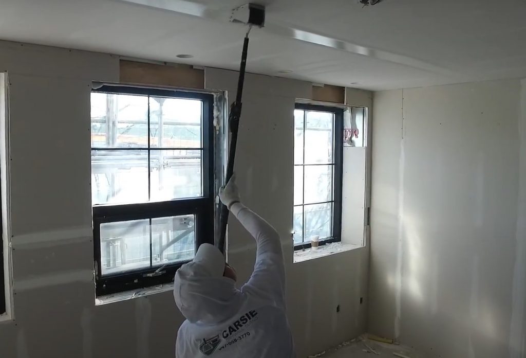 carsie team applying sealing on ceiling drywall -  how to drywall a ceiling